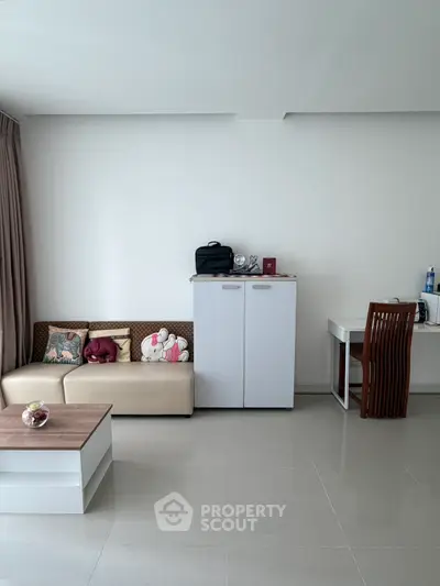 Modern living room with sleek furniture and minimalist decor, featuring a cozy sofa and elegant coffee table.