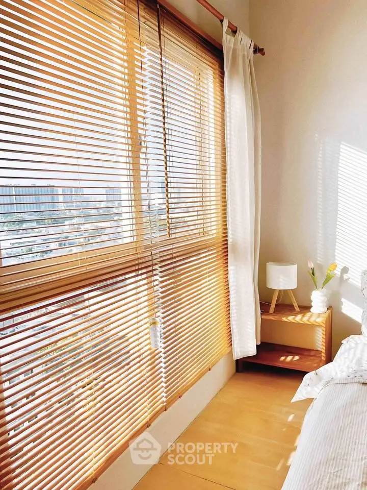 Bright bedroom with large window and wooden blinds offering city view