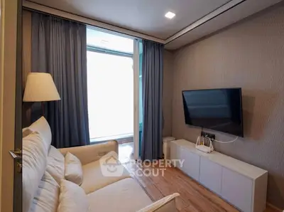 Modern living room with cozy sofa, wall-mounted TV, and elegant curtains.