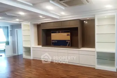 Spacious living room with built-in shelves and hardwood flooring, perfect for modern living.