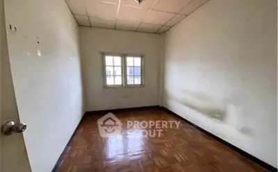 Spacious empty room with wooden flooring and natural light