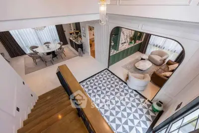 Luxurious open-plan living and dining area with elegant staircase and modern decor