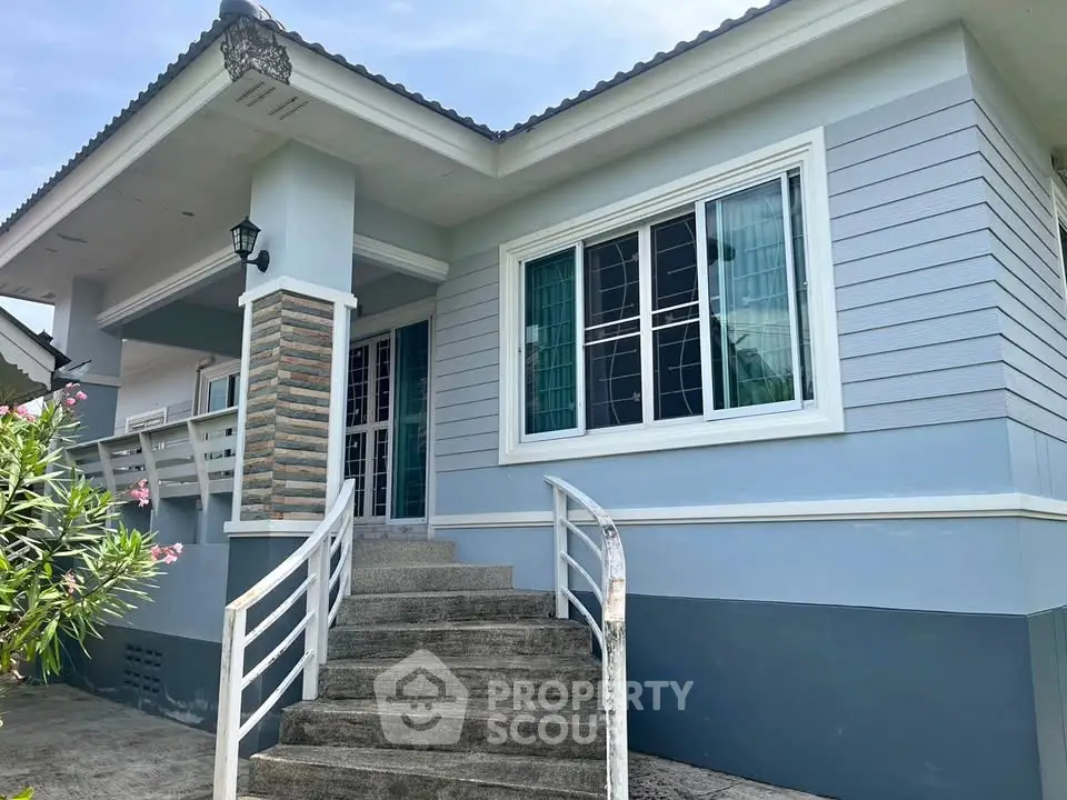 Charming single-story home with modern exterior and inviting entrance steps, perfect for family living.