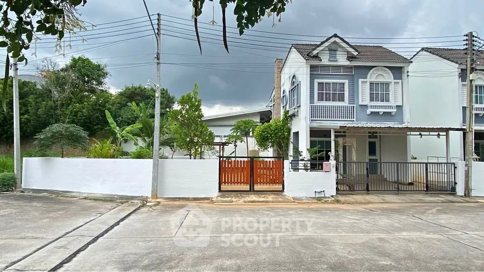 Charming two-story townhouse with gated entrance and lush greenery