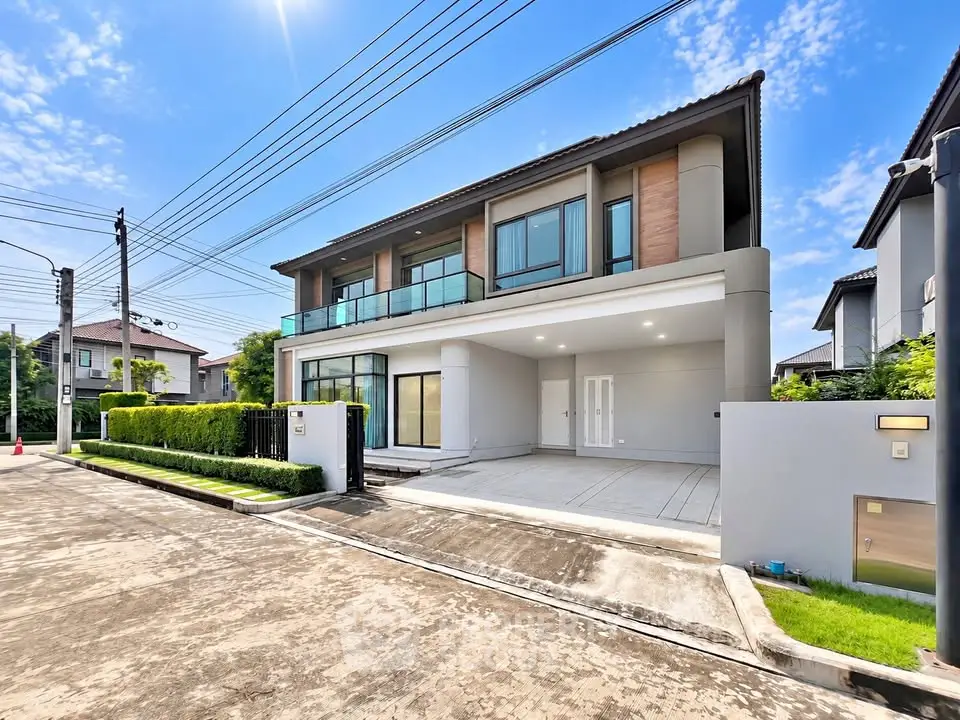 Modern two-story house with spacious driveway and lush greenery