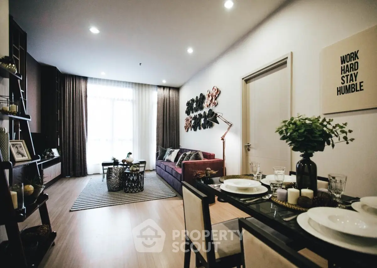 Stylish living room with modern decor and dining area, featuring elegant lighting and cozy ambiance.