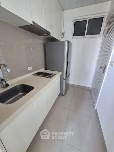 Modern kitchen with sleek design, featuring compact layout and stainless steel appliances.