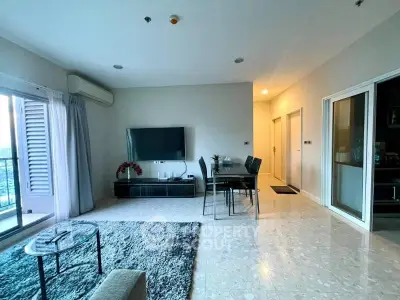 Spacious living room with modern decor and large windows offering natural light.