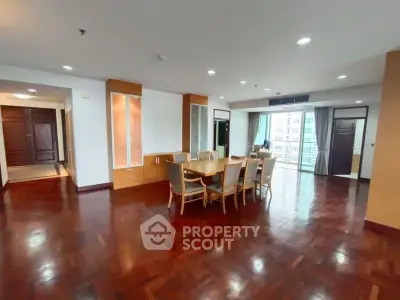 Spacious dining area with elegant wooden flooring and ample natural light in modern apartment.