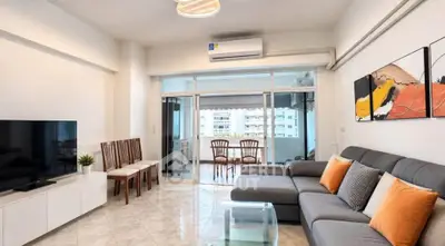 Spacious living room with modern decor and balcony view in a stylish apartment.