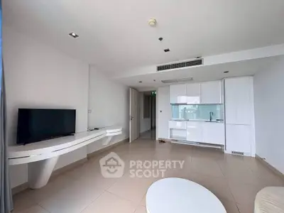 Modern minimalist living room with sleek white cabinetry and wall-mounted TV in a bright apartment.