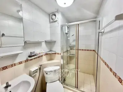 Compact bathroom with shower and modern fixtures in a cozy apartment.