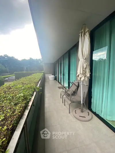 Spacious balcony with seating and lush greenery view