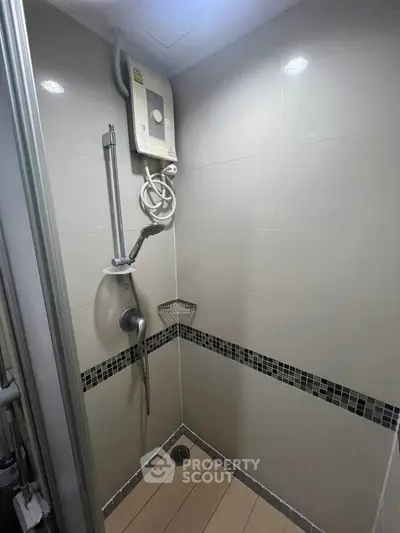 Modern bathroom shower area with sleek tiles and water heater