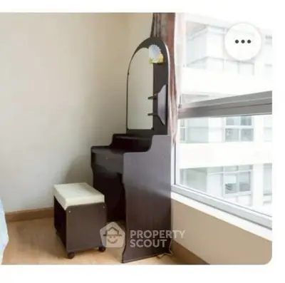 Cozy bedroom corner with a stylish vanity and large window view.