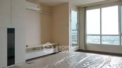 Spacious bedroom with large window offering stunning city views and modern air conditioning.