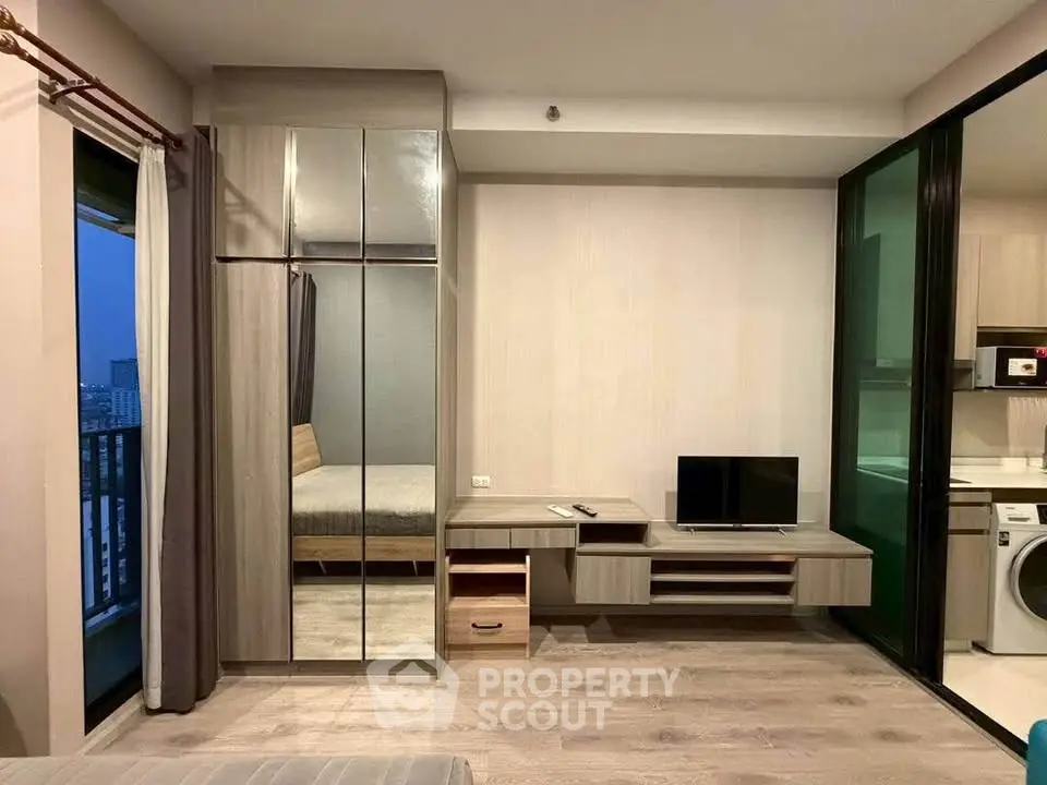 Modern apartment interior with mirrored wardrobe and compact living area