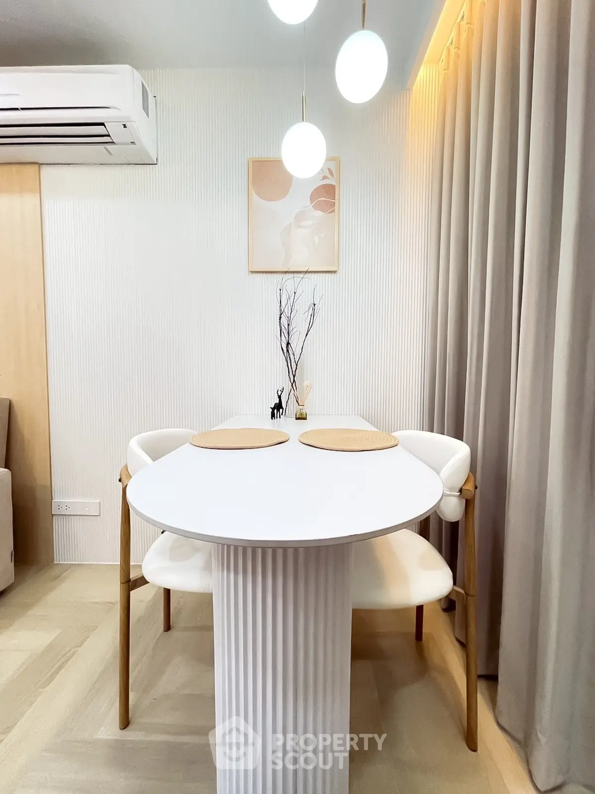 Modern dining area with elegant round table and stylish chairs under chic lighting.
