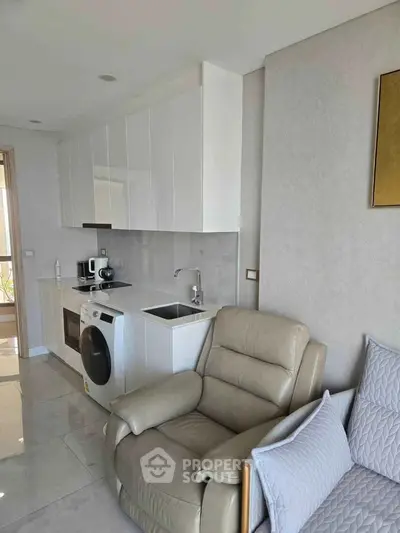 Modern compact kitchen with integrated appliances and cozy seating area