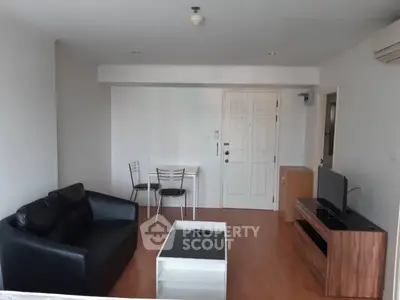 Modern living room with sleek furniture and wooden flooring in a cozy apartment.
