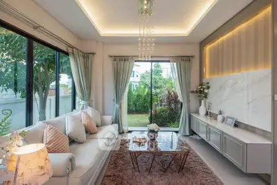 Luxurious living room with elegant decor and garden view, featuring plush seating and modern lighting.
