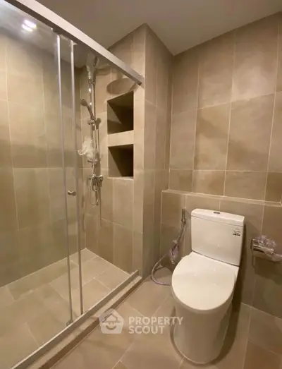 Modern bathroom with sleek shower and toilet in neutral tones