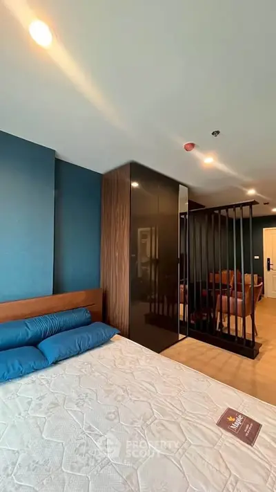 Modern bedroom with stylish decor and partial view of living area, featuring sleek design and cozy ambiance.