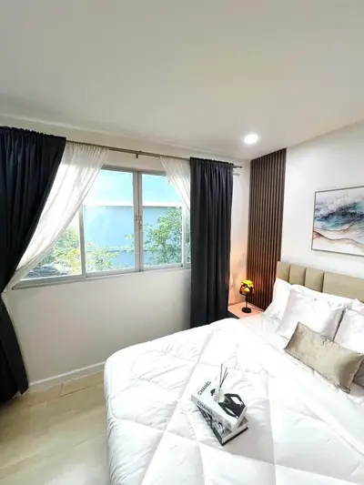 Cozy bedroom with elegant decor and large window offering natural light