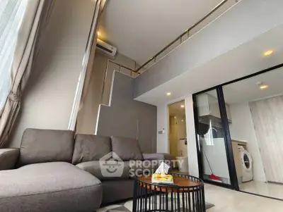 Modern loft-style living room with high ceiling and washing machine