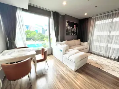Modern living room with large windows and stylish furniture overlooking a scenic view.