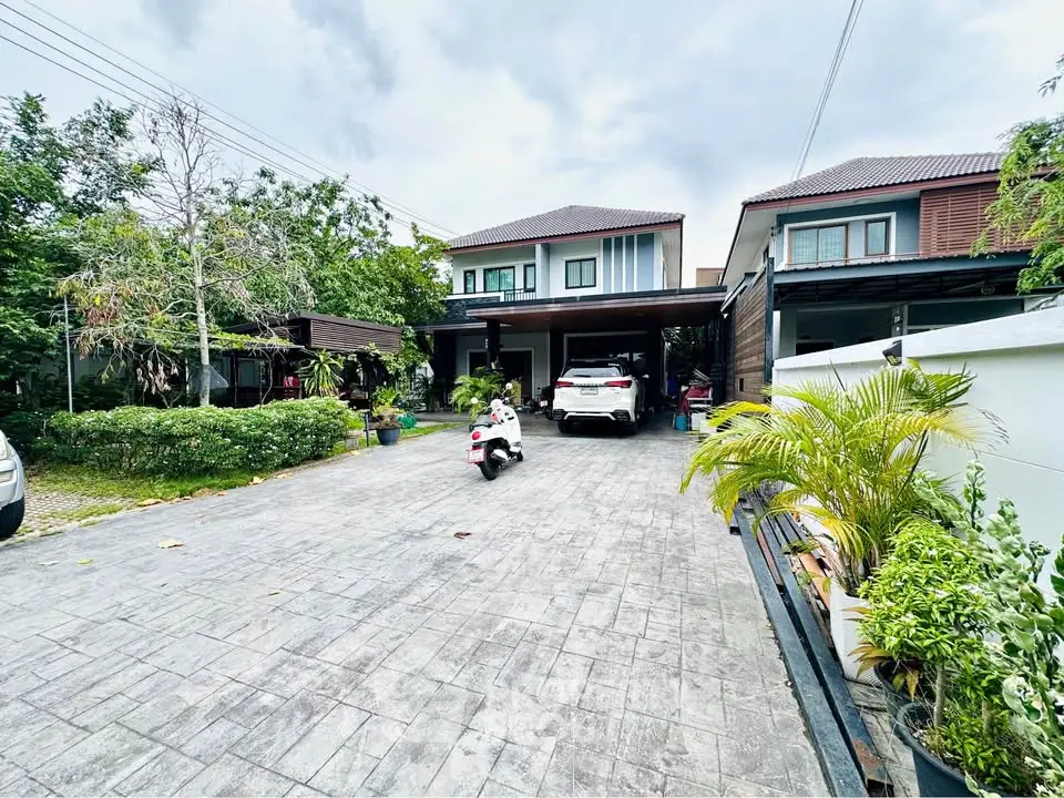 Spacious modern home with large driveway and lush greenery in a serene neighborhood.