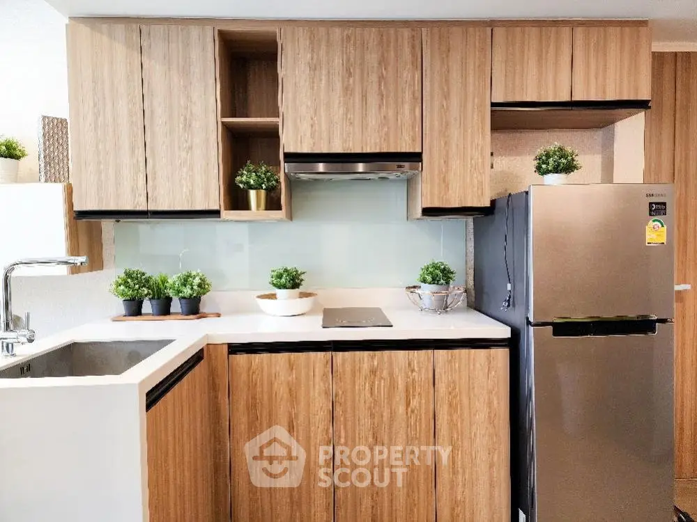 Modern kitchen with sleek wooden cabinets and stainless steel fridge