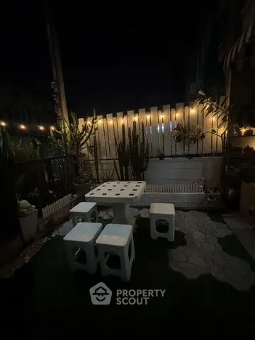 Charming night garden with cozy seating and ambient lighting, perfect for relaxation and entertaining.