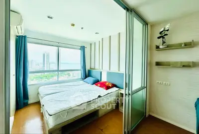 Bright bedroom with large window offering stunning city views, modern decor, and ample natural light.
