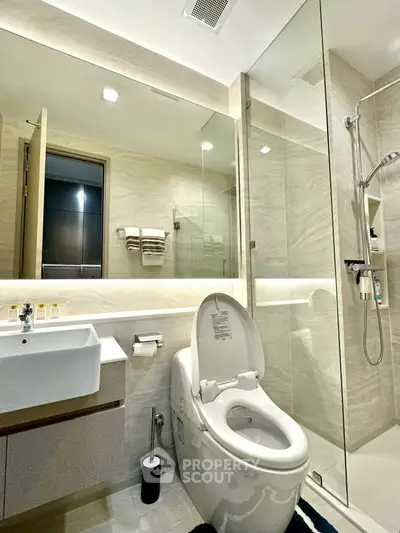 Modern bathroom with sleek fixtures and glass shower enclosure in a luxury apartment.