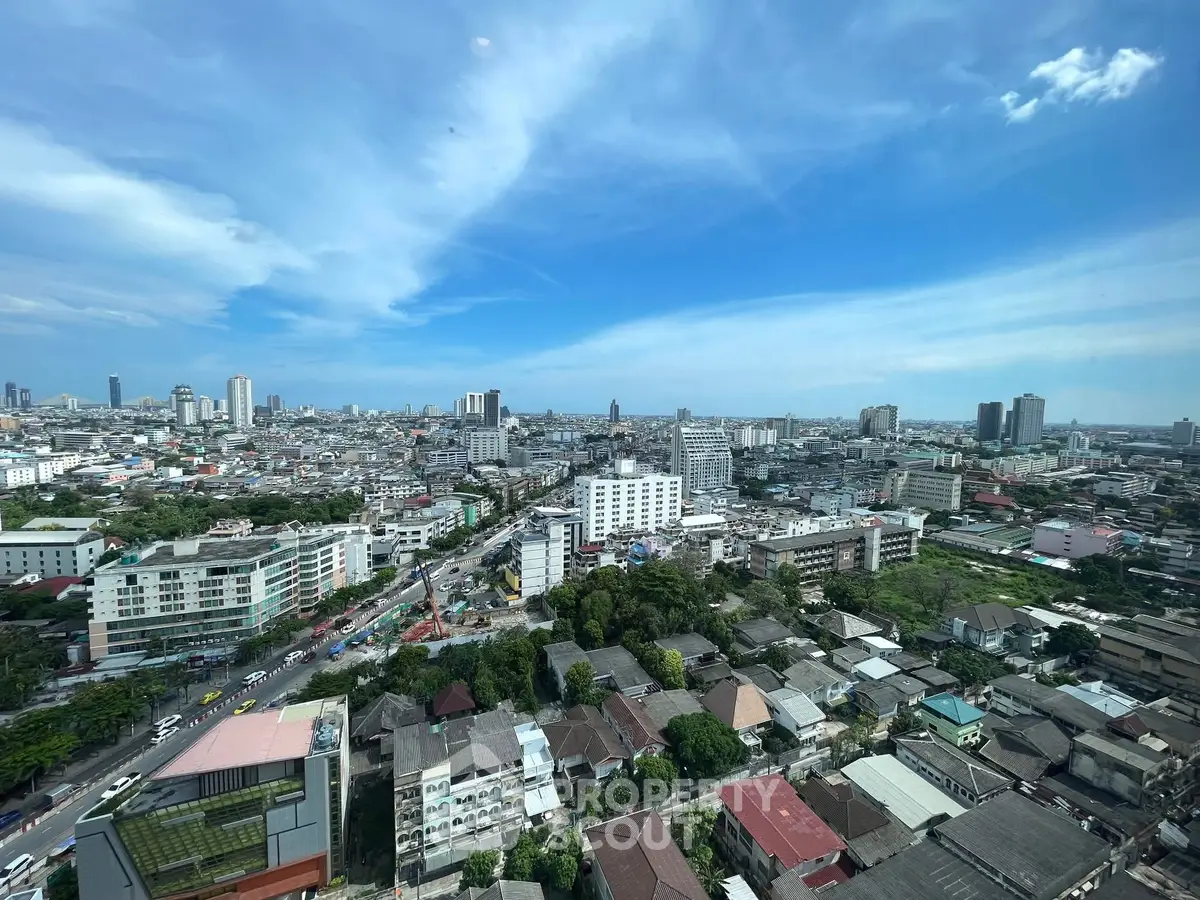 Stunning cityscape view from high-rise building showcasing urban skyline under clear blue sky.