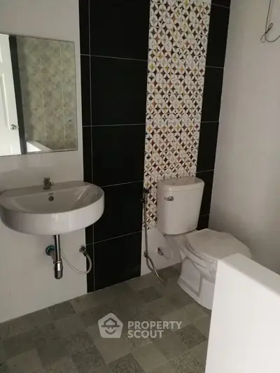 Modern bathroom with stylish tile accent wall and sleek fixtures.