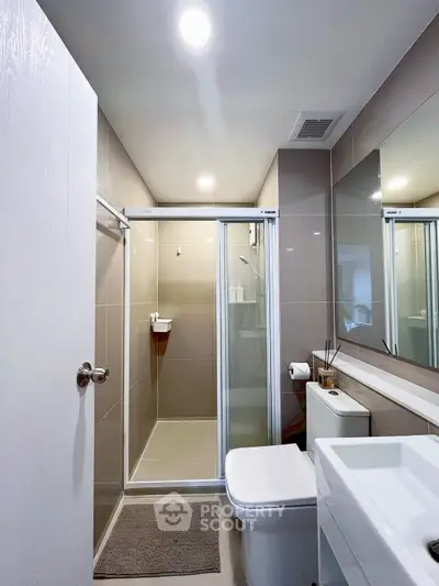 Modern bathroom with sleek shower and contemporary fixtures in a stylish apartment.