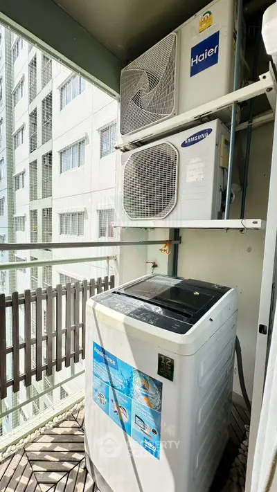 Modern balcony with washing machine and air conditioning units in urban apartment.