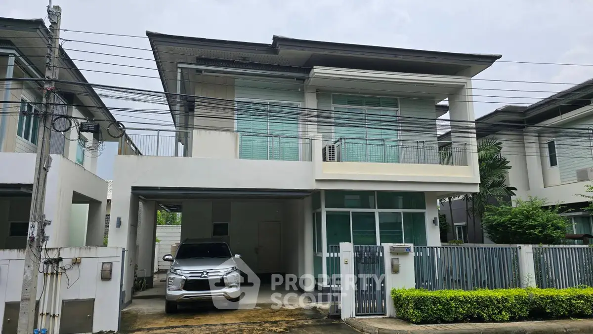 Modern two-story house with carport and sleek design in suburban neighborhood.