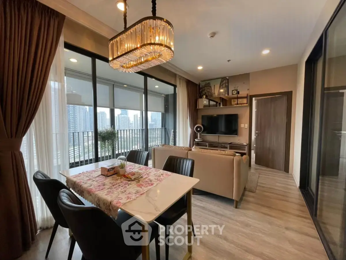 Luxurious living room with elegant chandelier and city view, perfect for modern urban living.