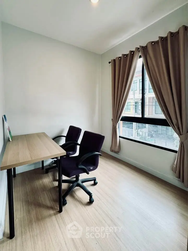 Bright study room with modern desk and chairs, large window with curtains