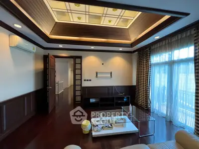 Luxurious living room with elegant ceiling design and large windows for natural light.