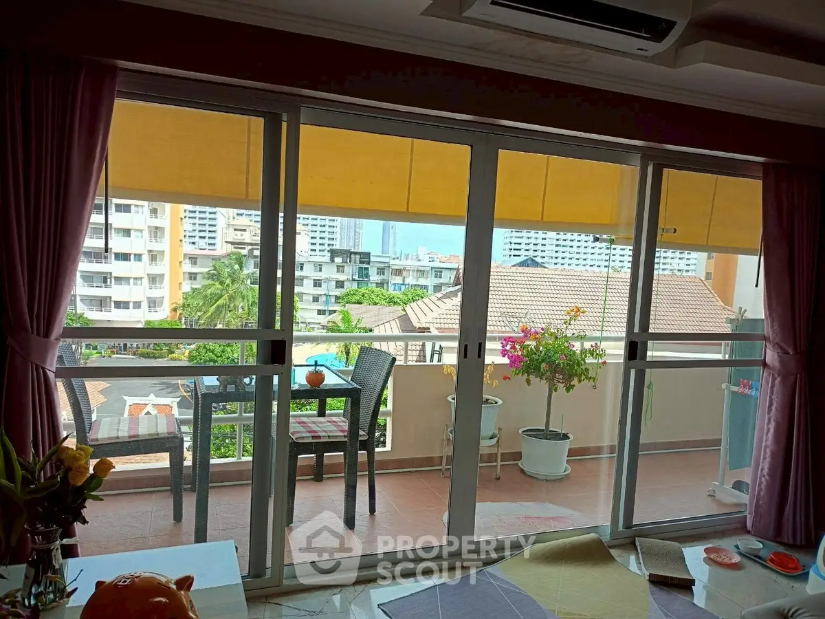 Spacious balcony with city view and cozy seating area