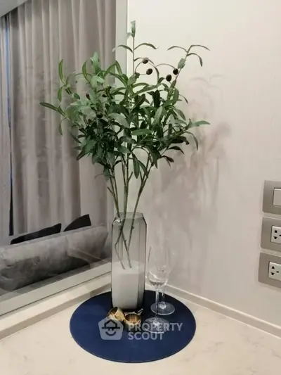 Elegant interior decor with a modern vase and greenery on a stylish countertop, perfect for enhancing living spaces.
