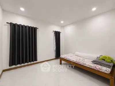 Minimalist bedroom with single bed and modern curtains, perfect for cozy living.