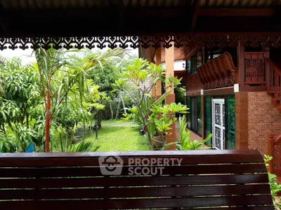 Charming wooden house with lush garden view and intricate architectural details.