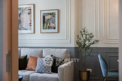 Stylish living room with modern decor, featuring a cozy sofa, elegant wall art, and chic furnishings.