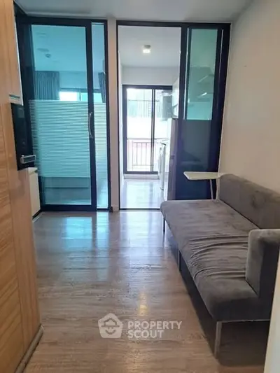 Modern apartment interior with sleek wooden flooring and stylish glass partitions.