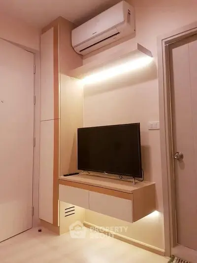 Modern living room with sleek TV unit and air conditioning in stylish apartment.